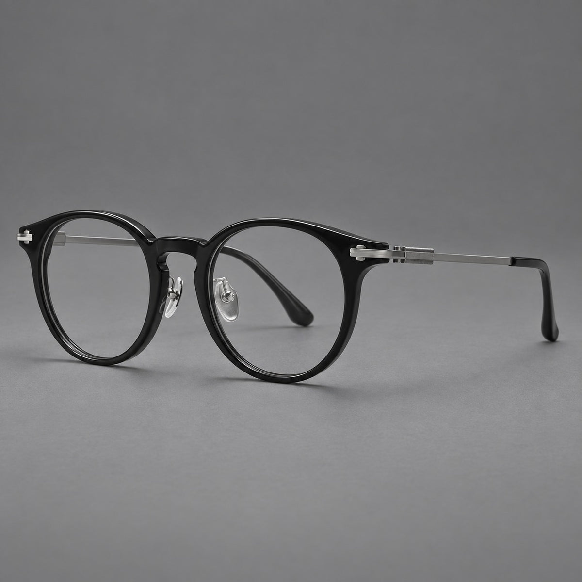 Retro acetate and titanium eyeglasses with round rims and a pronounced keyhole bridge in Black / Grey, three quarter view