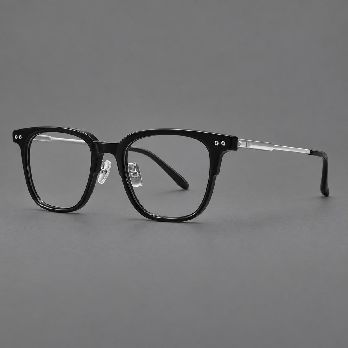 Classic acetate and titanium eyeglasses with squared brows and paired corner rivets in Black / Silver, three quarter view
