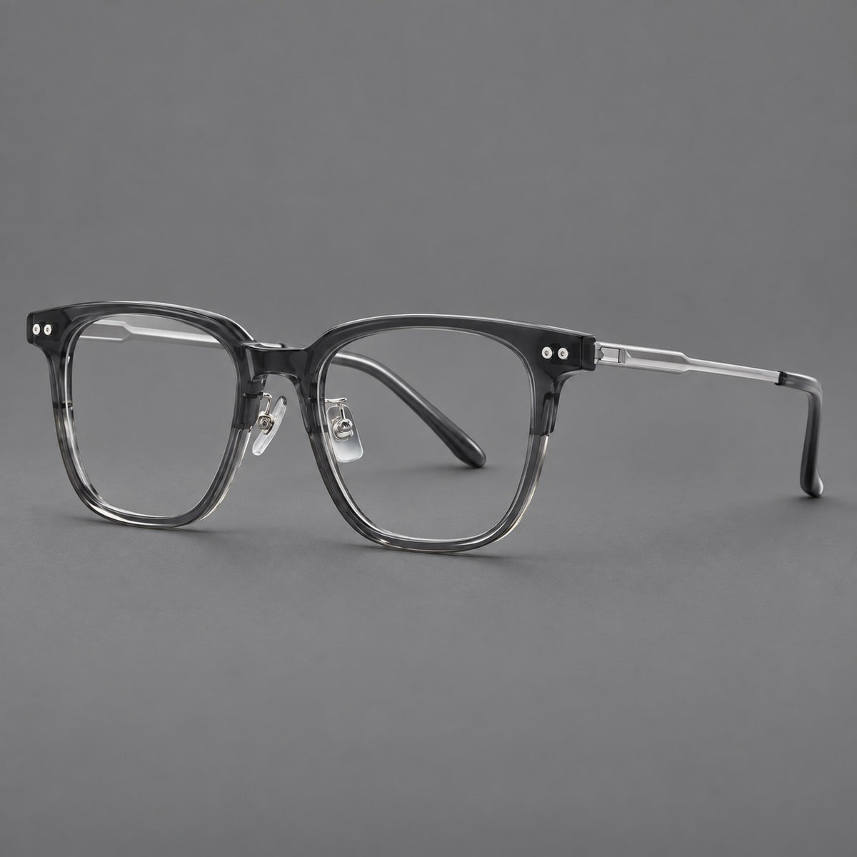 Classic acetate and titanium eyeglasses with squared brows and paired corner rivets in Clear Grey / Silver, three quarter view