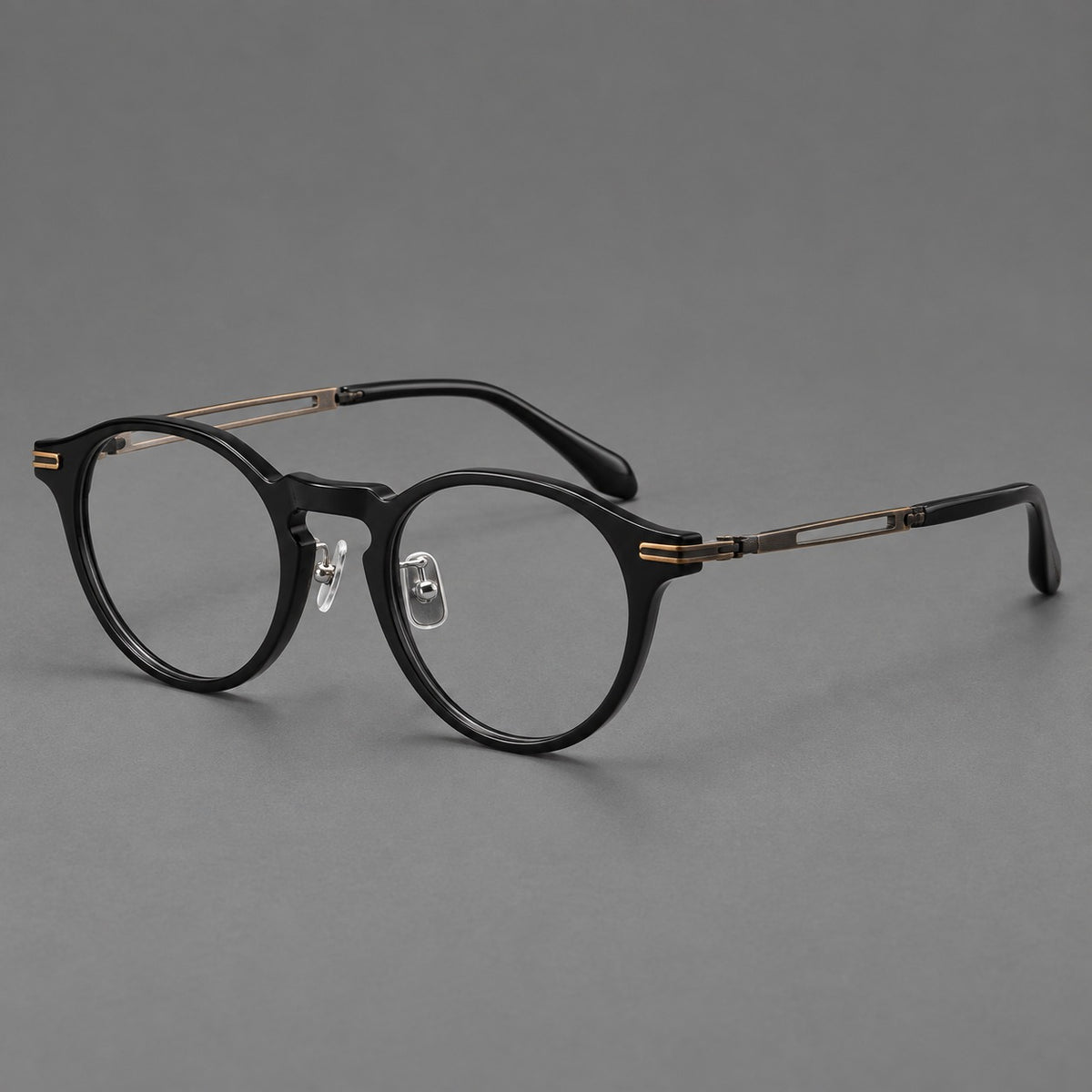 Retro acetate and titanium eyeglasses with round rims and distinctive looped metal joints in Black / Antique Bronze, three quarter view