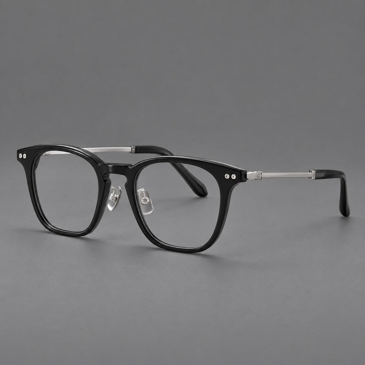 Retro acetate and titanium eyeglasses with gently squared rims and circular metal hinges in Black / Silver, three quarter view