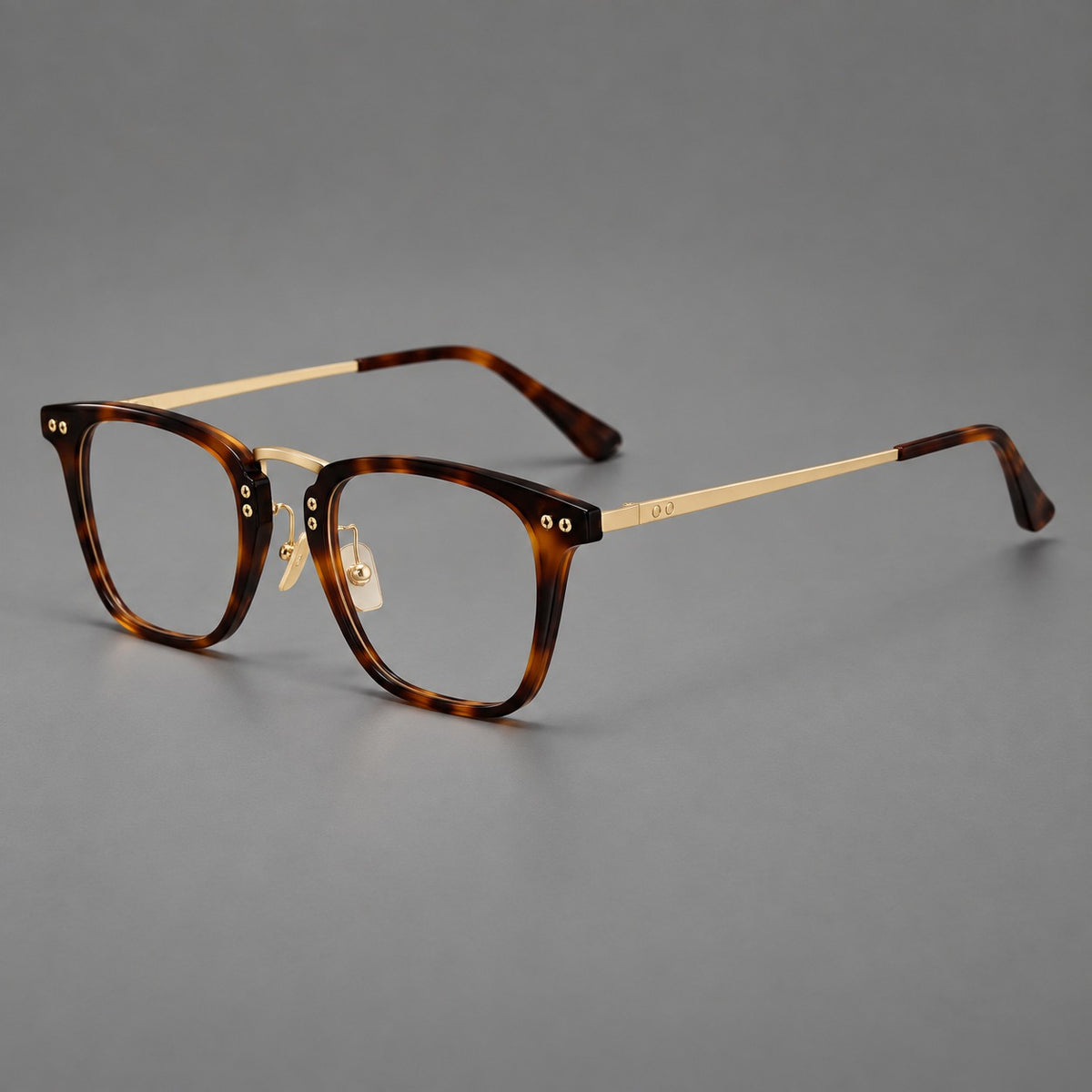 Acetate and titanium eyeglasses with soft square rims and an arched metal bridge in Tortoiseshell / Gold, three quarter view