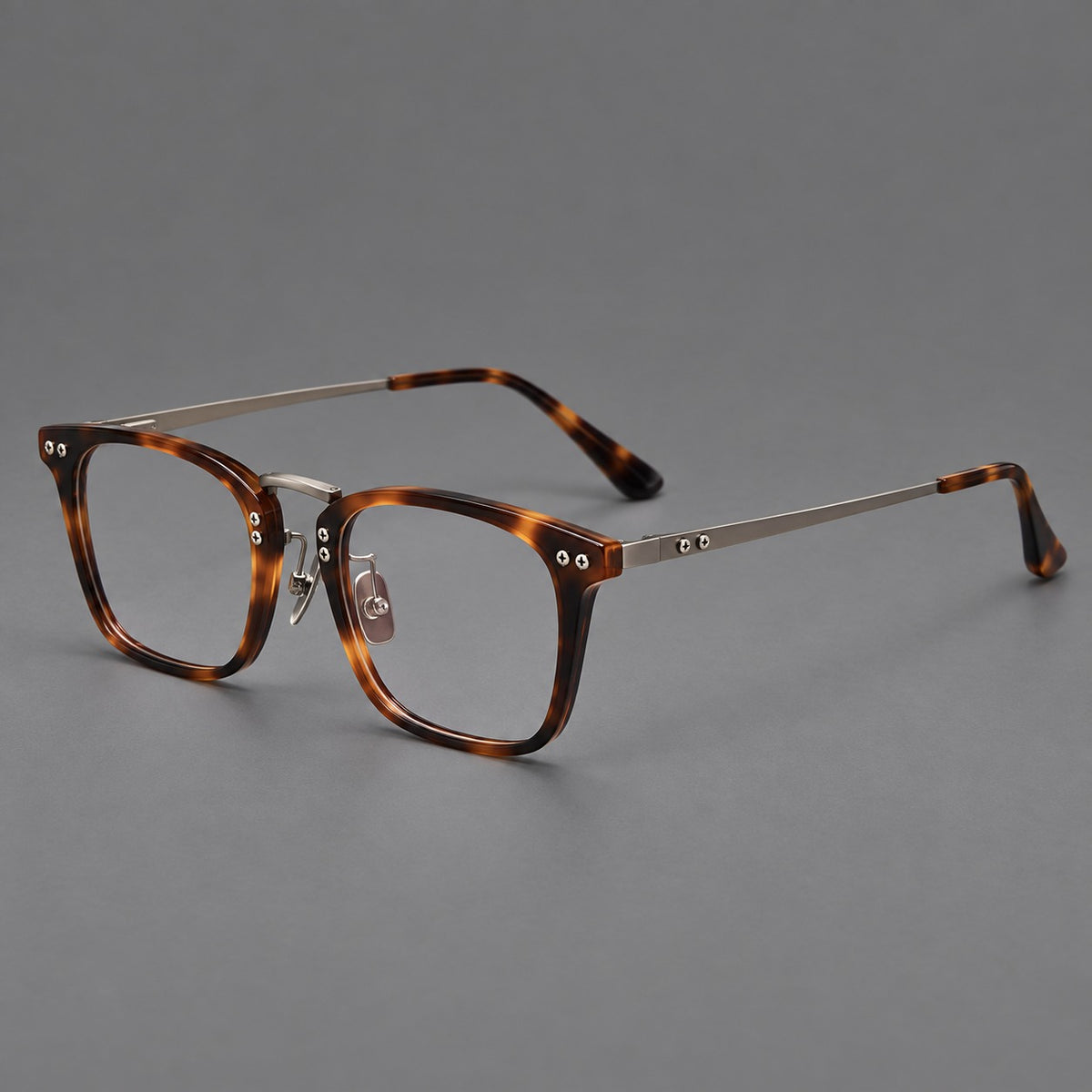 Acetate and titanium eyeglasses with angular rectangular rims and a curved metal bridge in Tortoiseshell / Gunmetal, three quarter view