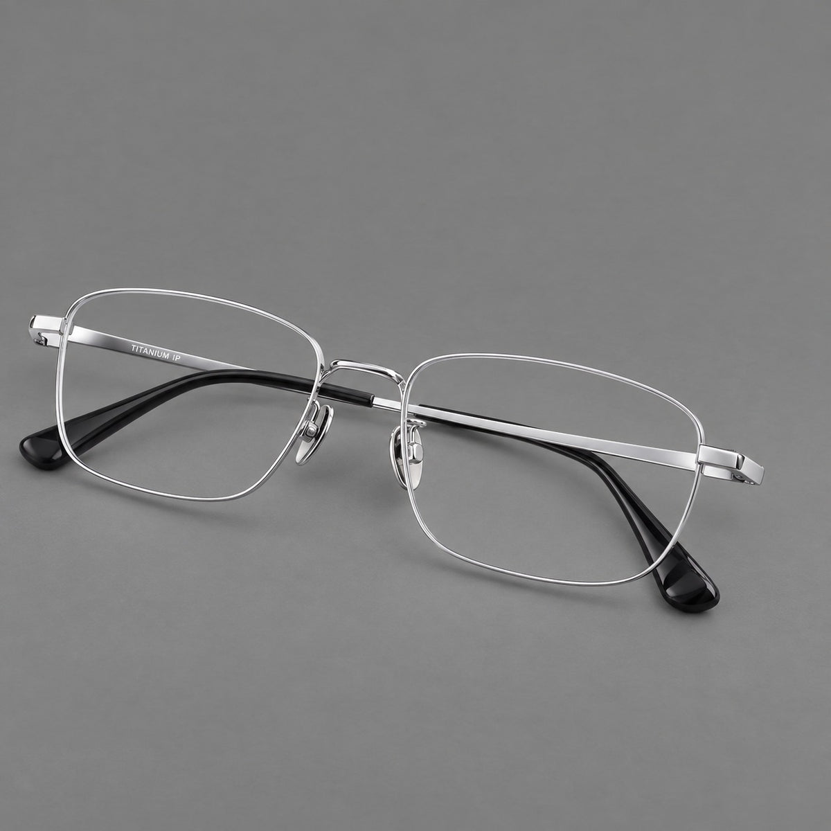 Modern square titanium glasses with an angular bridge and broad straight temples in Silver, three quarter view