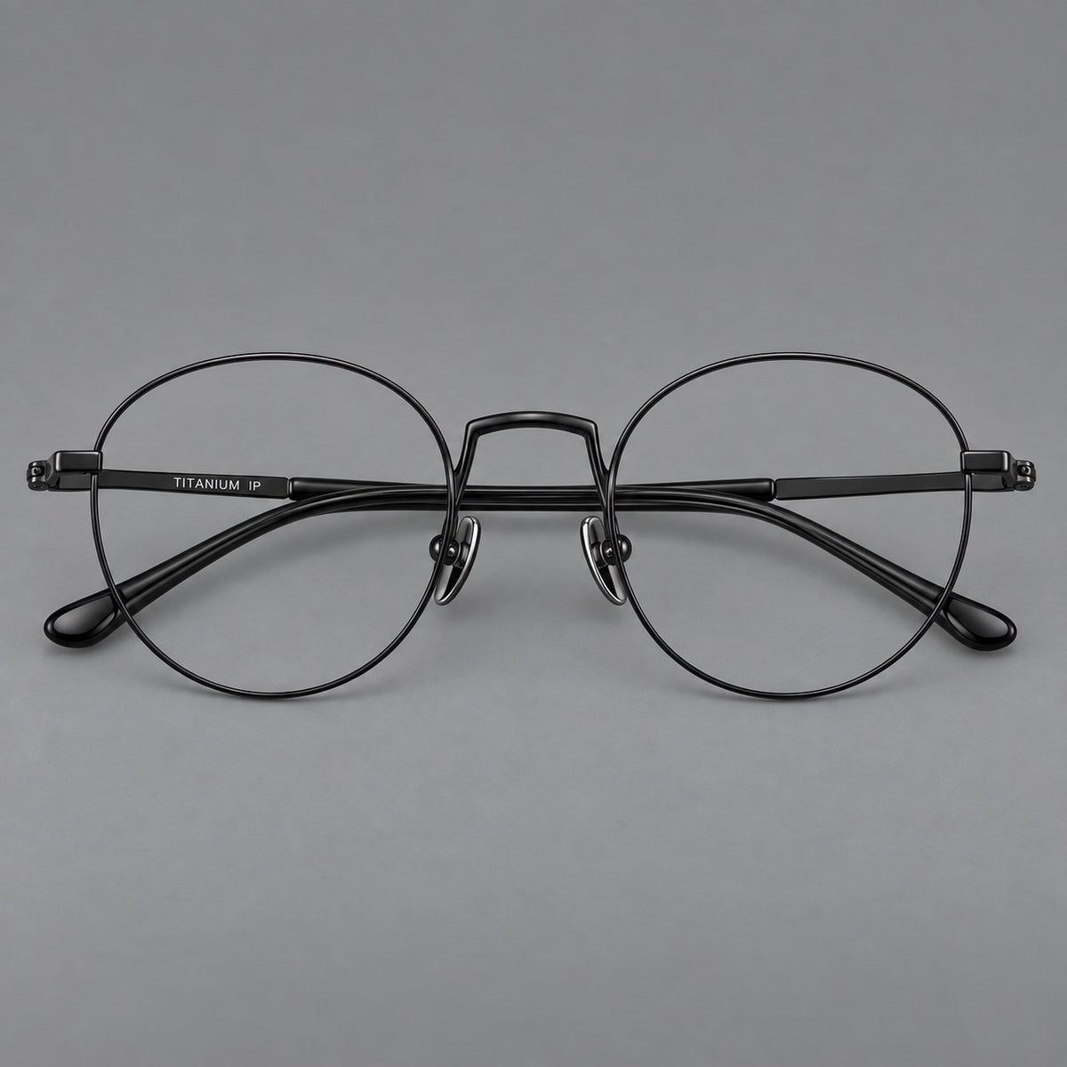 Retro round titanium glasses with a raised bridge and smooth corner shoulders in Black, front view