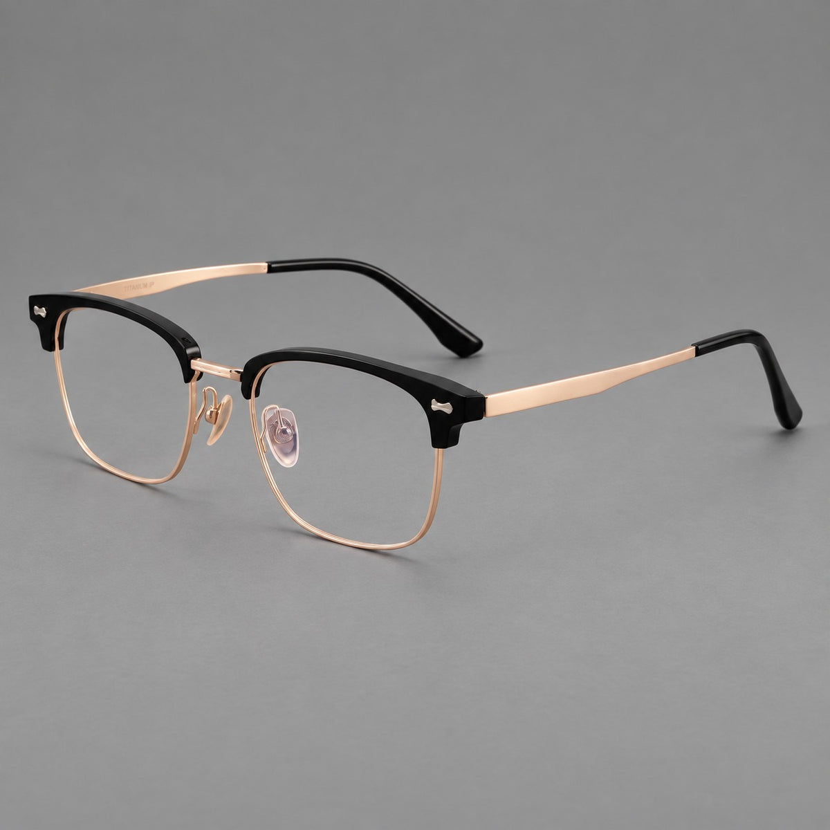 Classic browline titanium glasses with fine lower rims and subtle corner accents in Black and Rose Gold, three quarter view