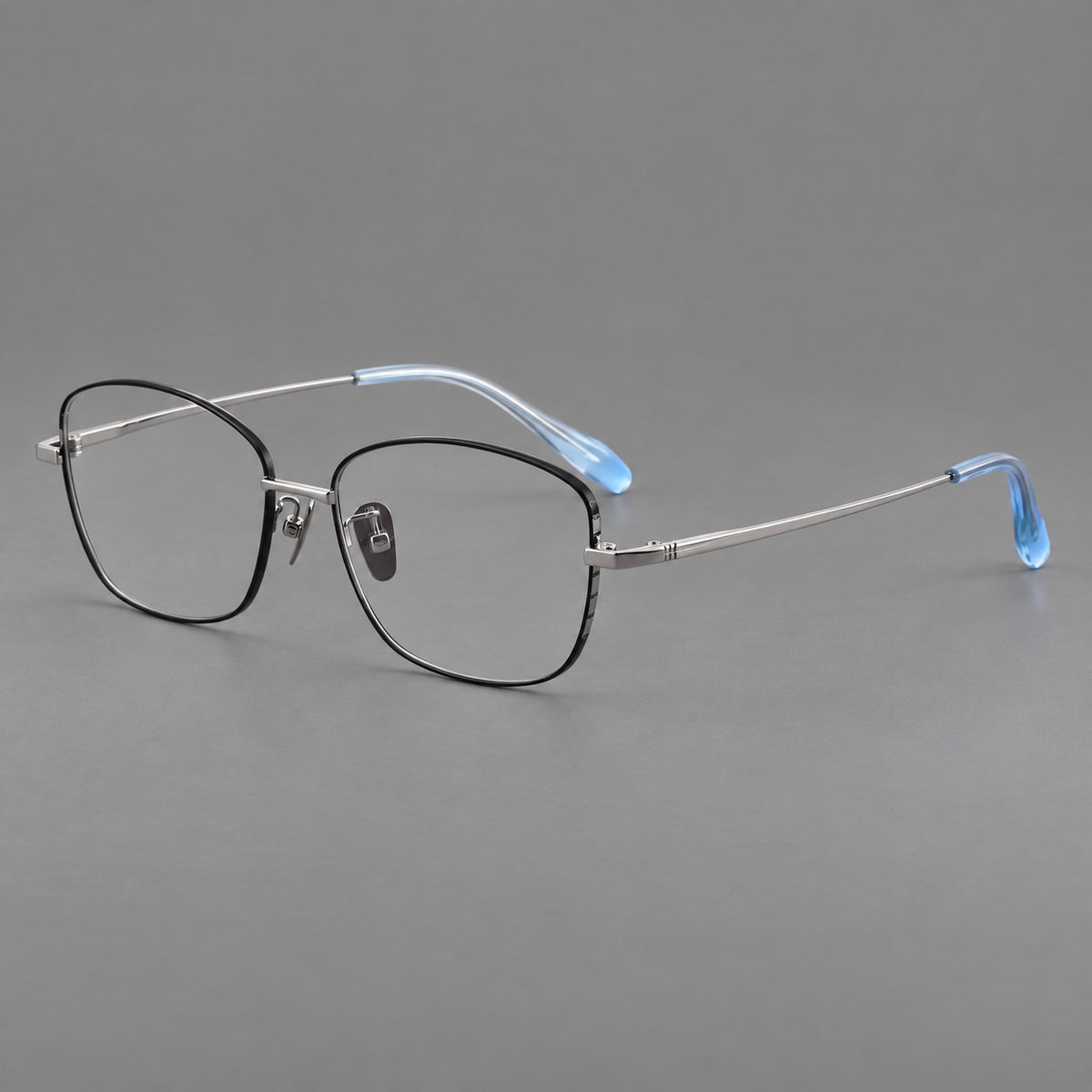 Soft square titanium glasses with angled upper corners and decorated hinges in Black and Silver, three quarter view