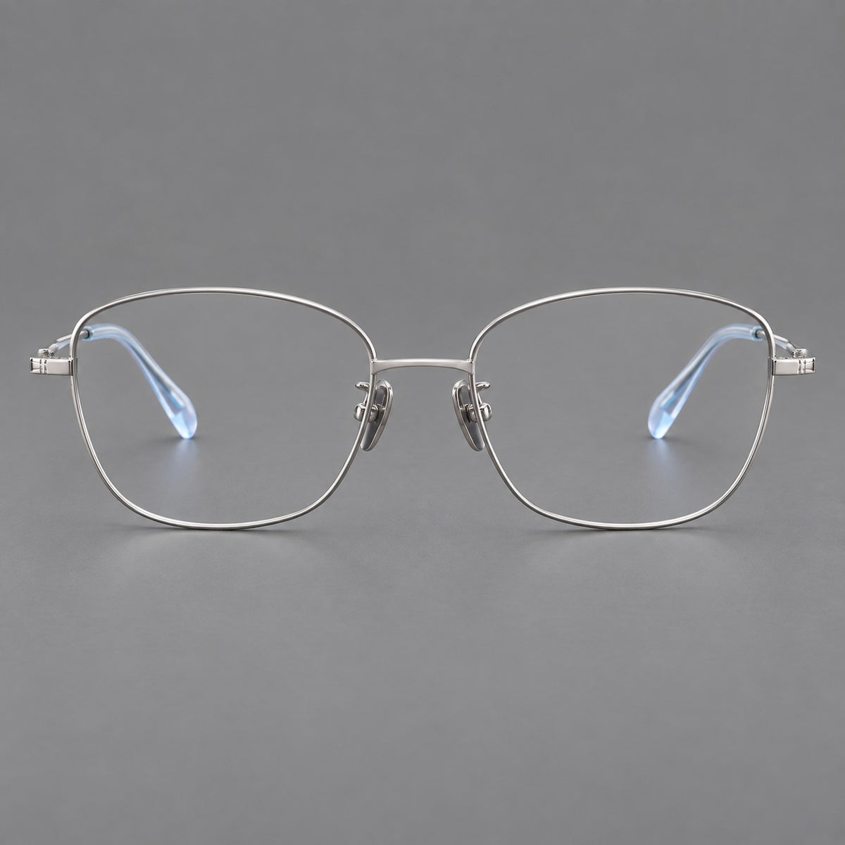 Soft square titanium glasses with angled upper corners and decorated hinges in Silver, front view