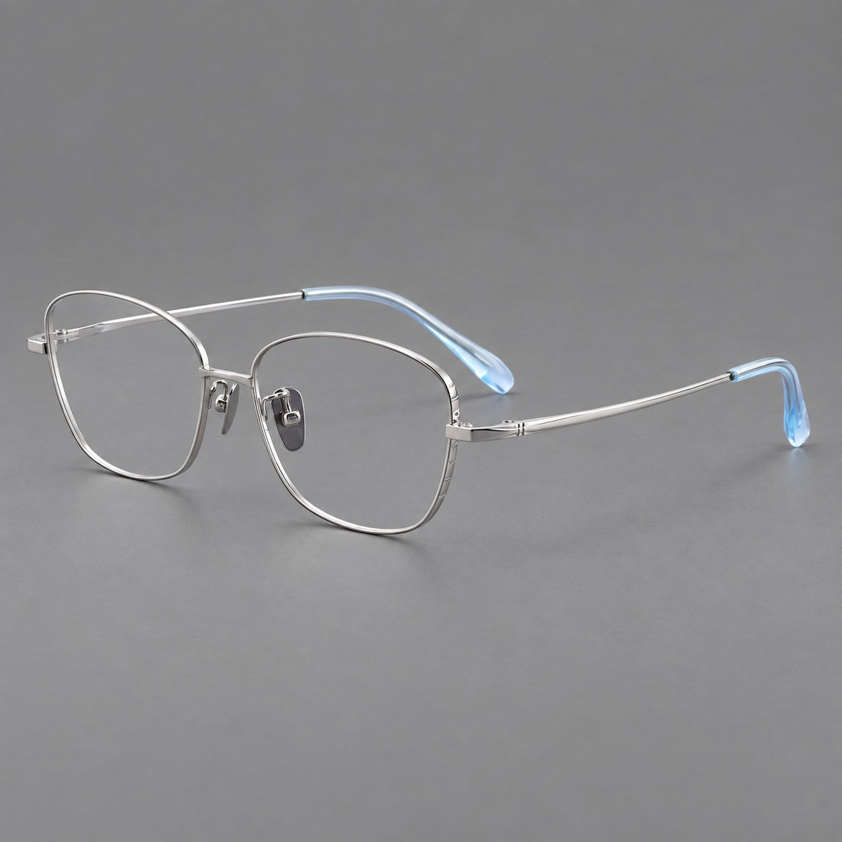 Soft square titanium glasses with angled upper corners and decorated hinges in Silver, three quarter view