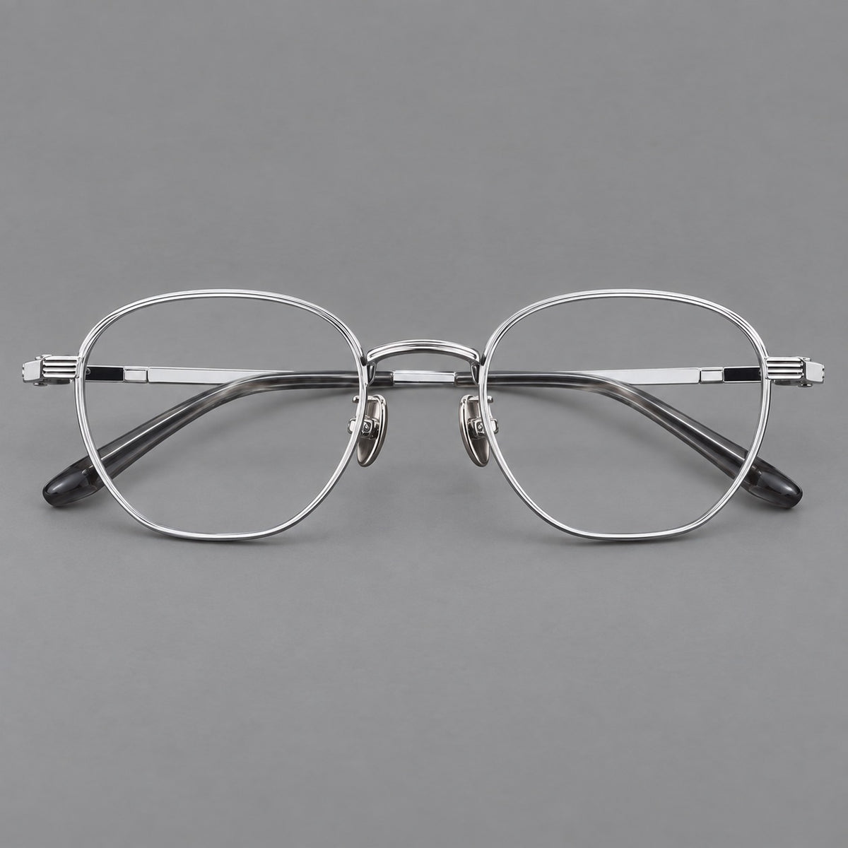 Retro panto titanium glasses with a curved bridge and fine parallel rim grooves in Black and Silver, front view
