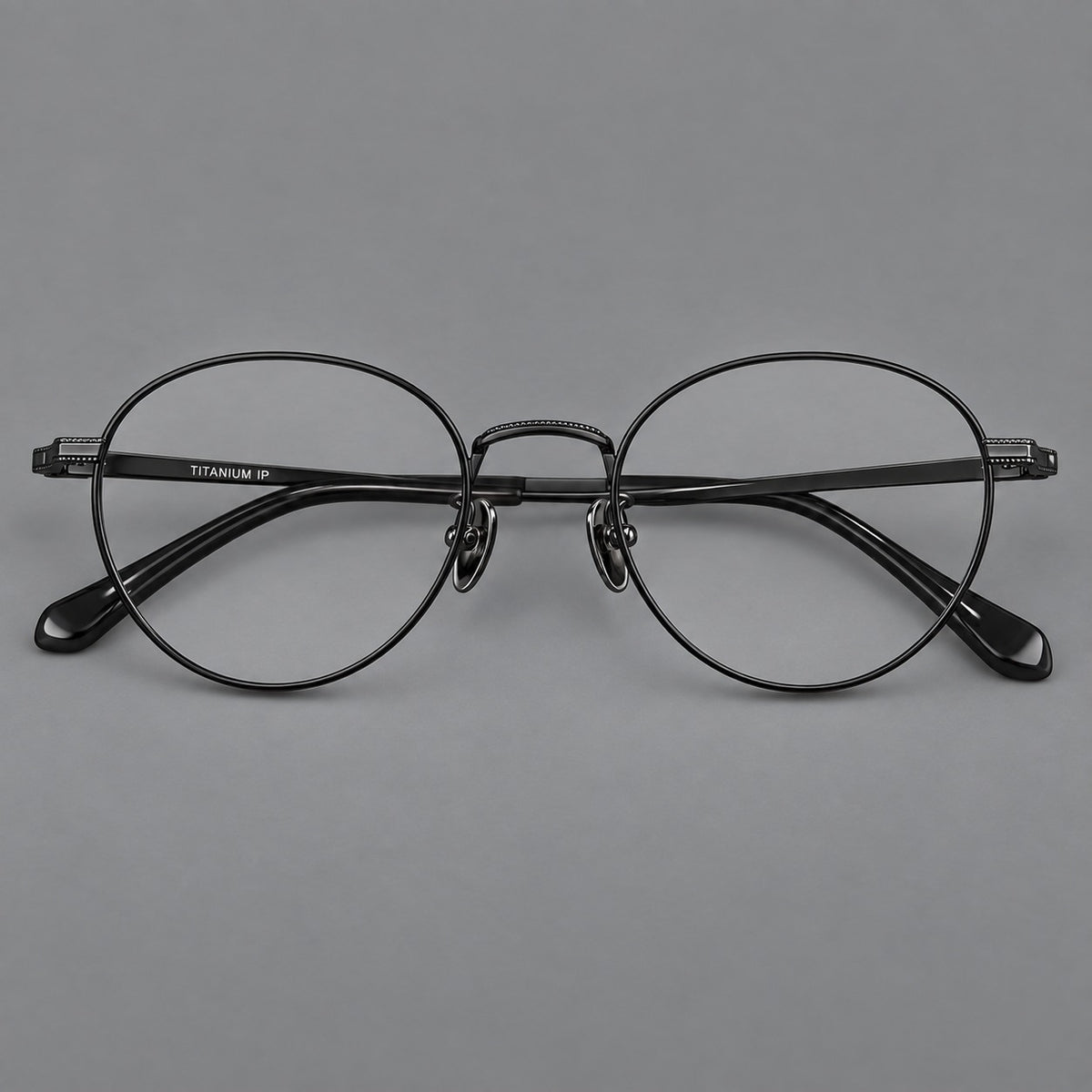 Rounded panto titanium glasses with a raised bridge and dotted temple accents in Black, front view
