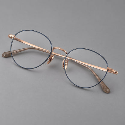 Rounded panto titanium glasses with a raised bridge and dotted temple accents in Blue and Rose Gold, three quarter view front view