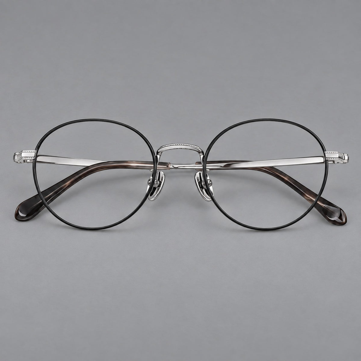 Rounded panto titanium glasses with a raised bridge and dotted temple accents in Black and Silver, front view