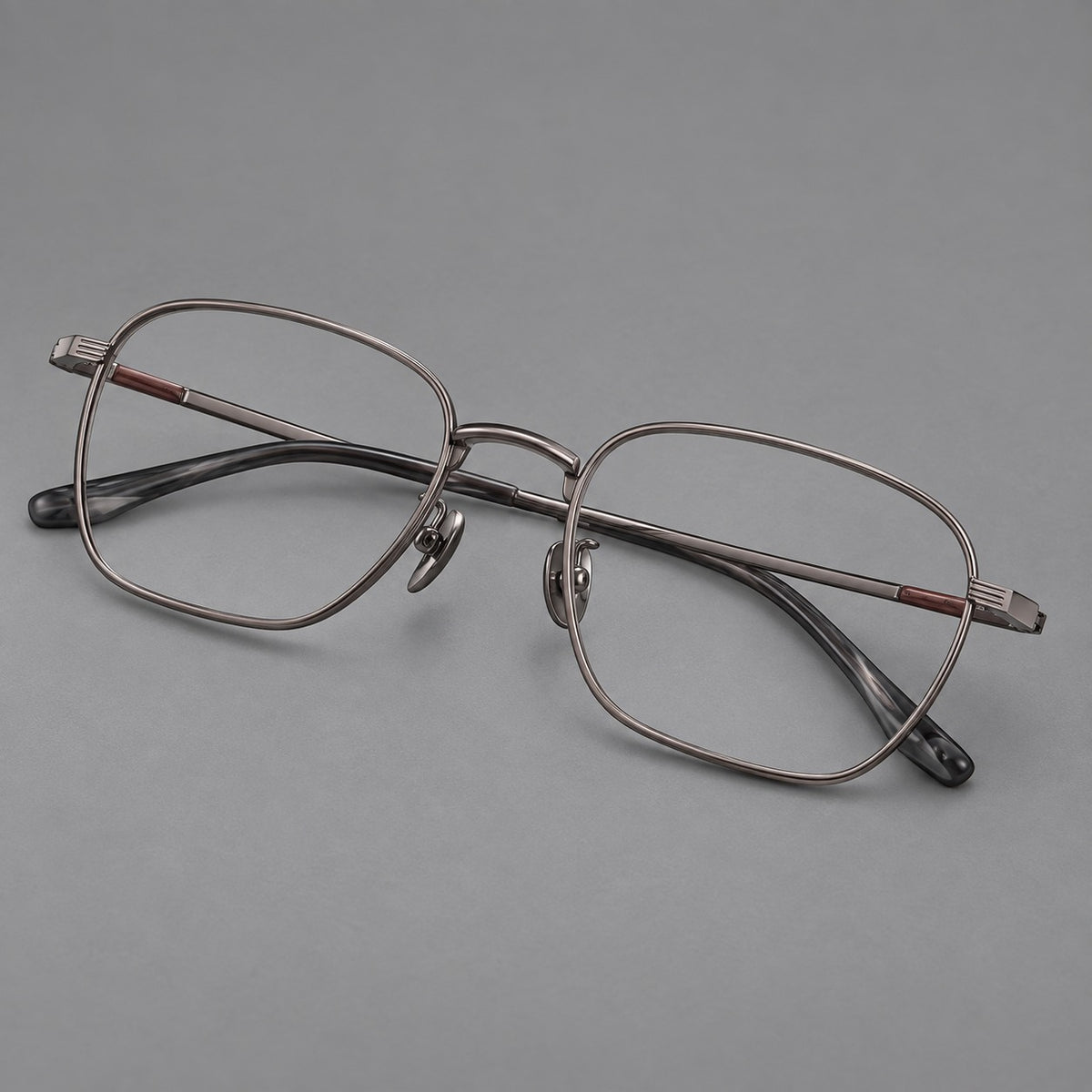 Deep square titanium glasses with a flatter brow and grooved outer shoulders in Gunmetal, three quarter view