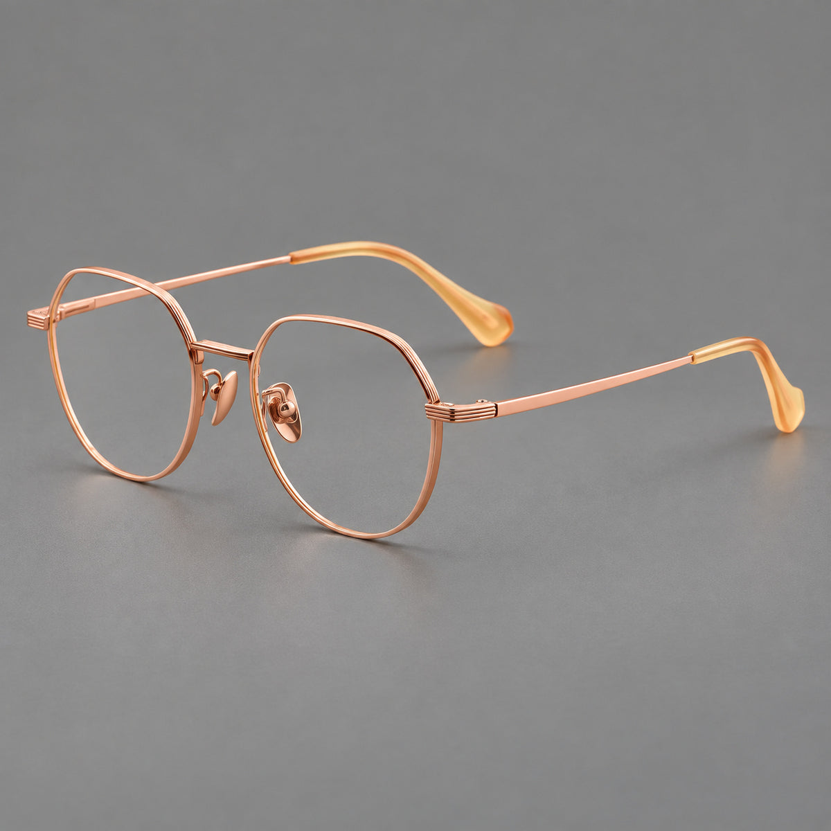 Geometric titanium glasses with soft polygonal rims and fine shoulder detailing in Rose Gold, three quarter view