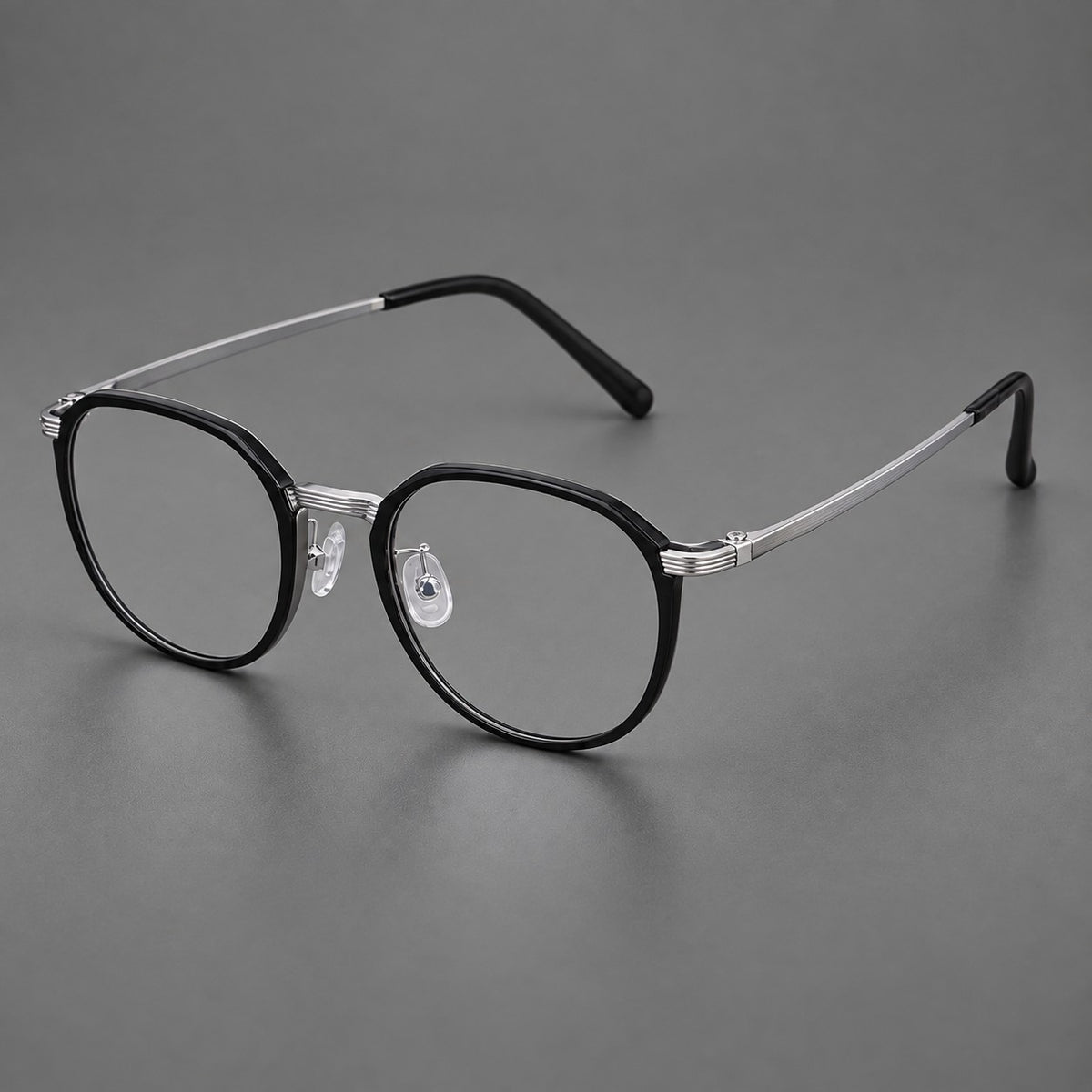 Geometric titanium glasses with flattened corners and a finely ridged bridge in Black and Silver, three quarter view