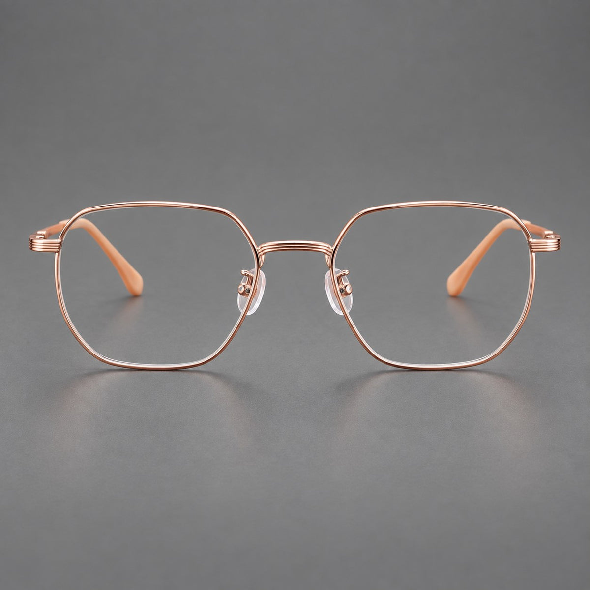 Geometric titanium glasses with flattened corners and a finely ridged bridge in Rose Gold, front view