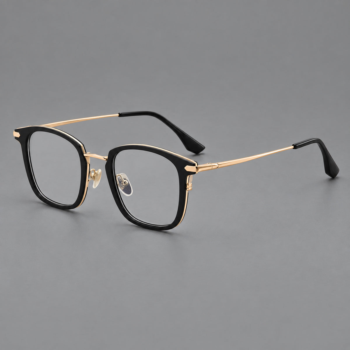 Bold square titanium glasses with a separate bridge and long metal corner accents in Black and Gold, three quarter view