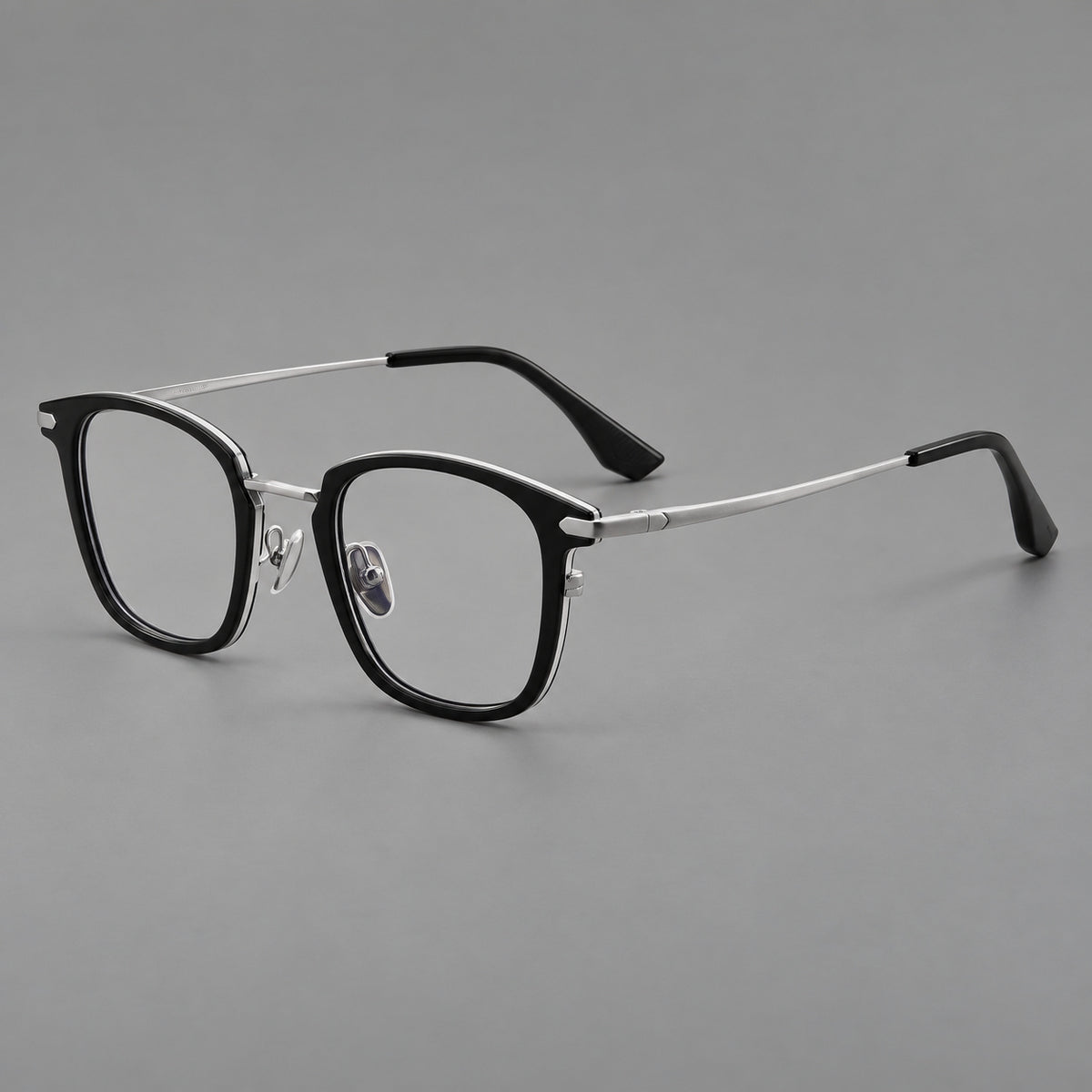 Bold square titanium glasses with a separate bridge and long metal corner accents in Black and Silver, three quarter view