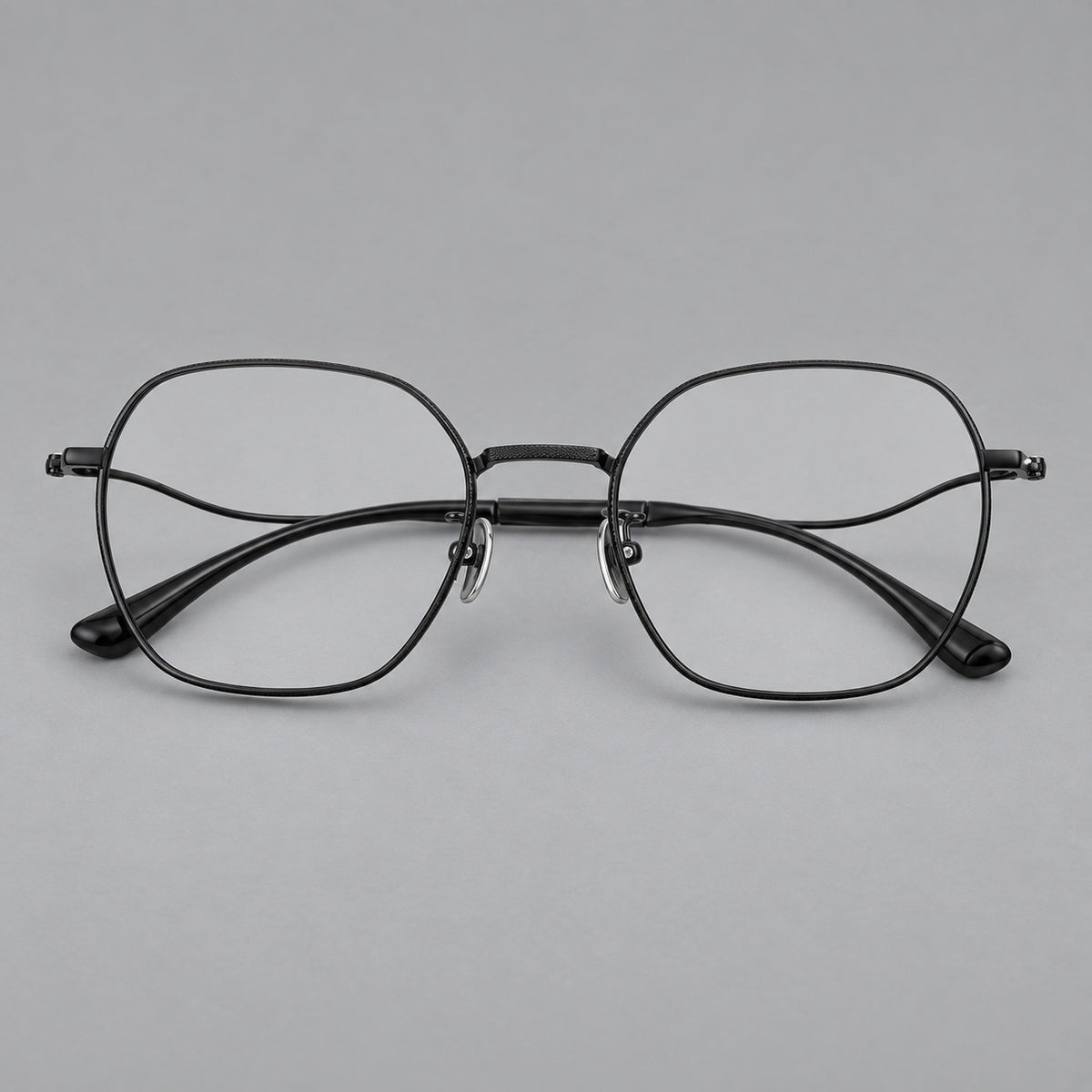 Geometric titanium glasses with engraved rim edges and curved temple joins in Black, front view