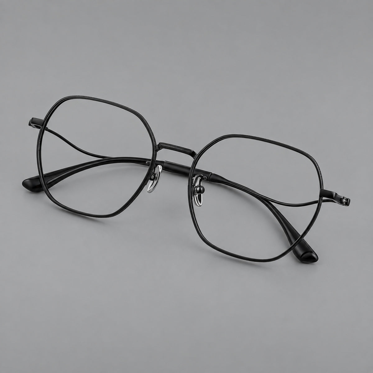 Geometric titanium glasses with engraved rim edges and curved temple joins in Black, three quarter view