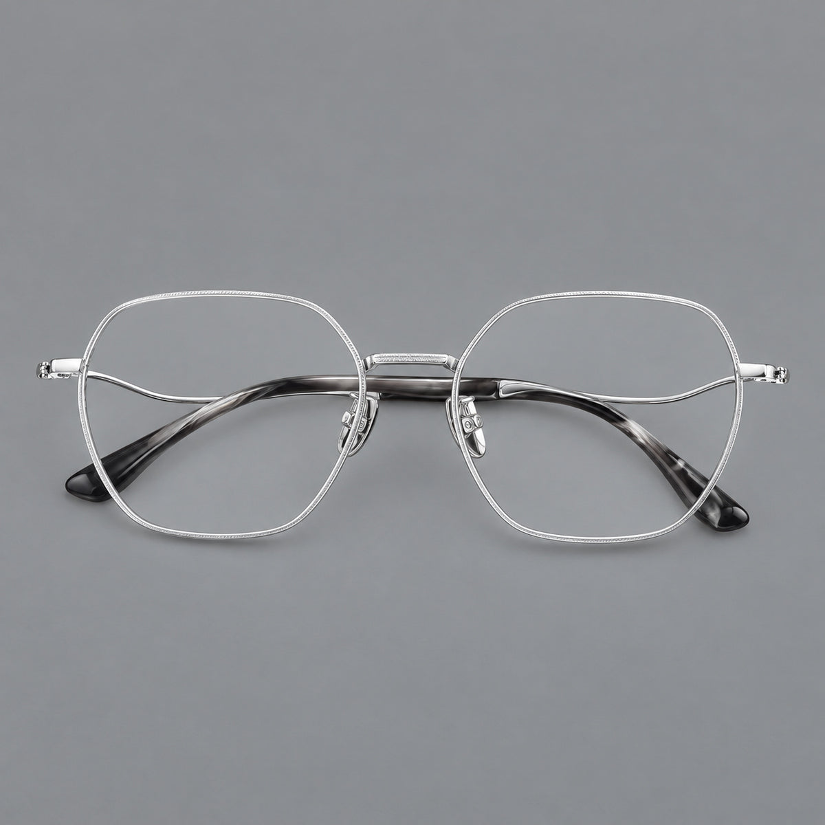 Geometric titanium glasses with engraved rim edges and curved temple joins in Silver, front view