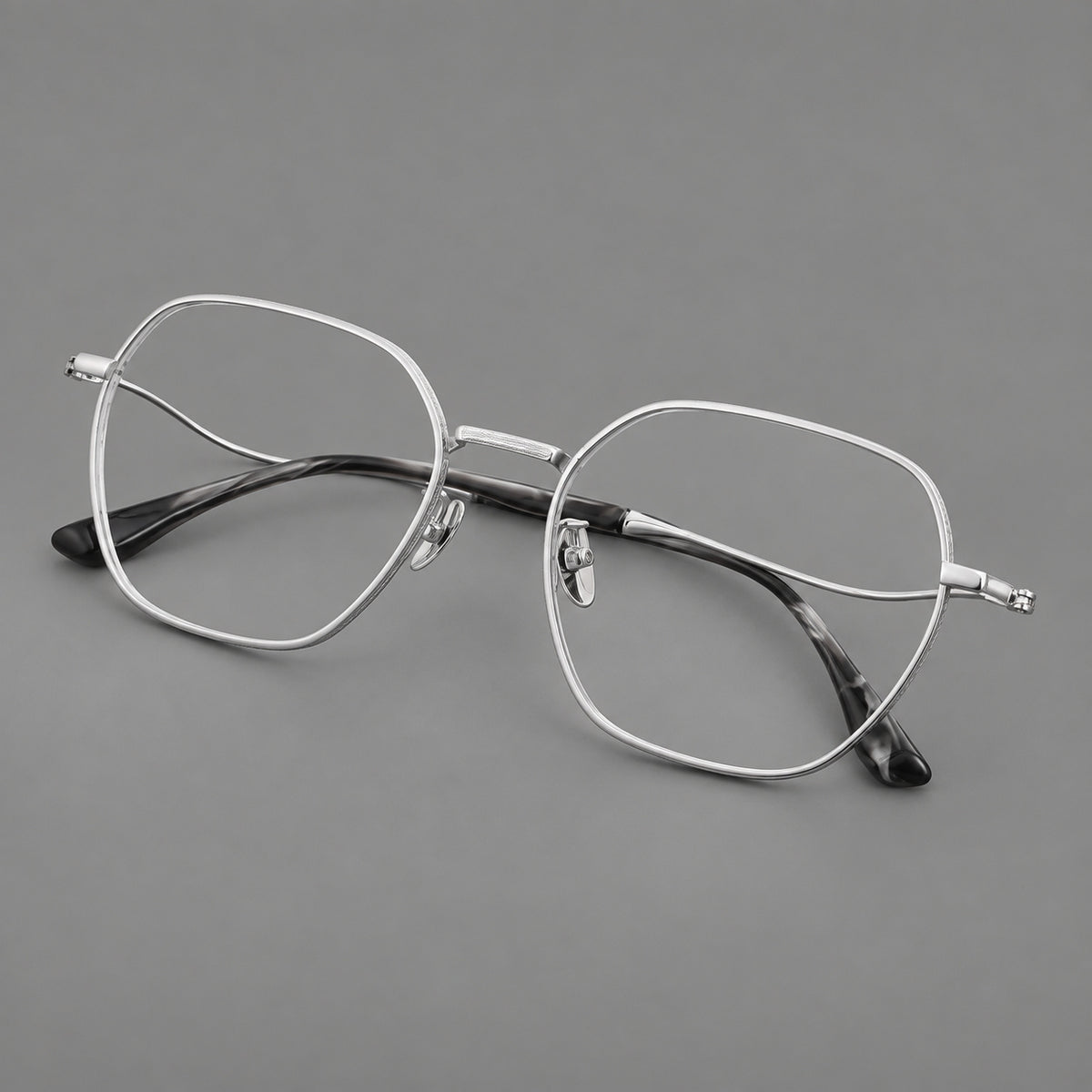 Geometric titanium glasses with engraved rim edges and curved temple joins in Silver, three quarter view