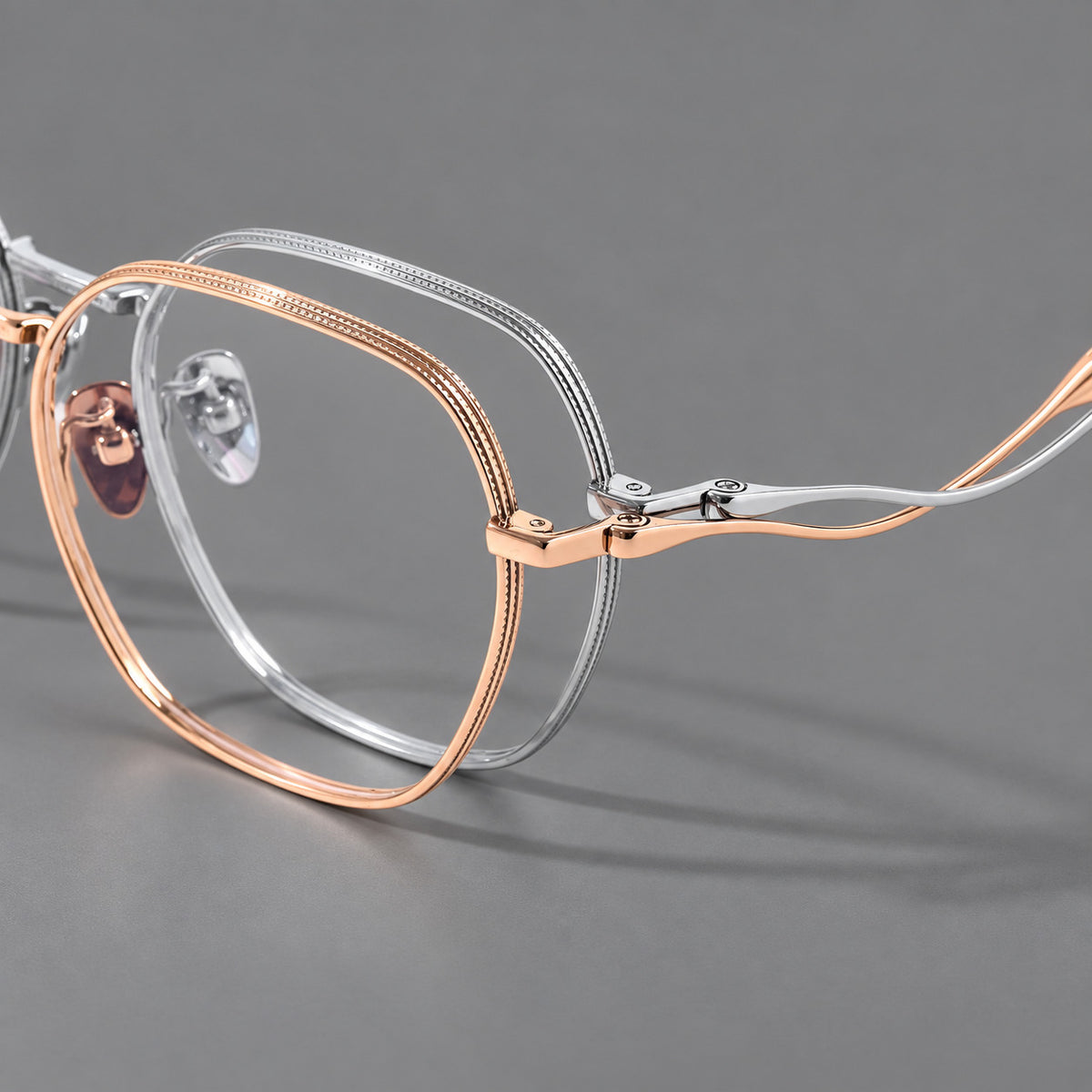 Geometric titanium glasses with engraved rim edges and curved temple joins, frame details