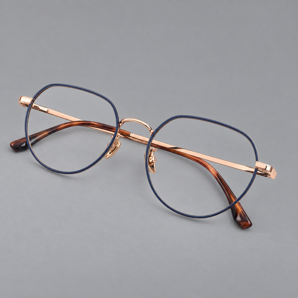 Classic panto titanium glasses with a curved bridge and slim straight temples in Blue and Rose Gold, three quarter view