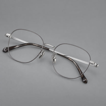 Retro panto titanium glasses with stepped corners and finely engraved temples in Grey and Silver, three quarter view lens detail