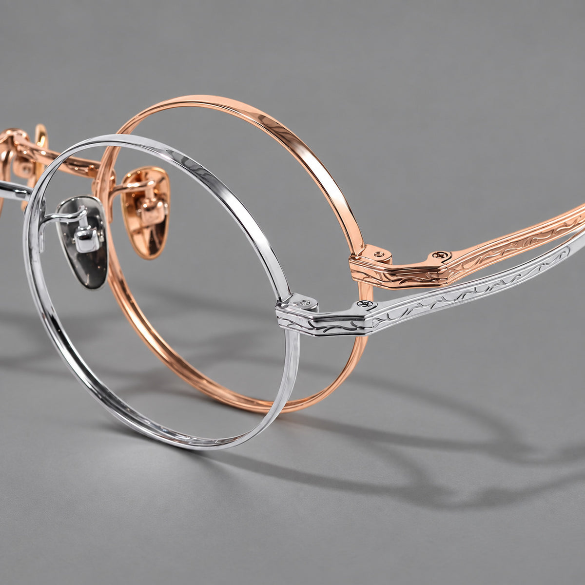 Compact circular titanium glasses with a curved bridge and wavy engraved temples, frame details