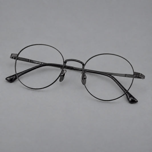 Classic circular titanium glasses with a raised bridge and lined temple accents in Black, three quarter view