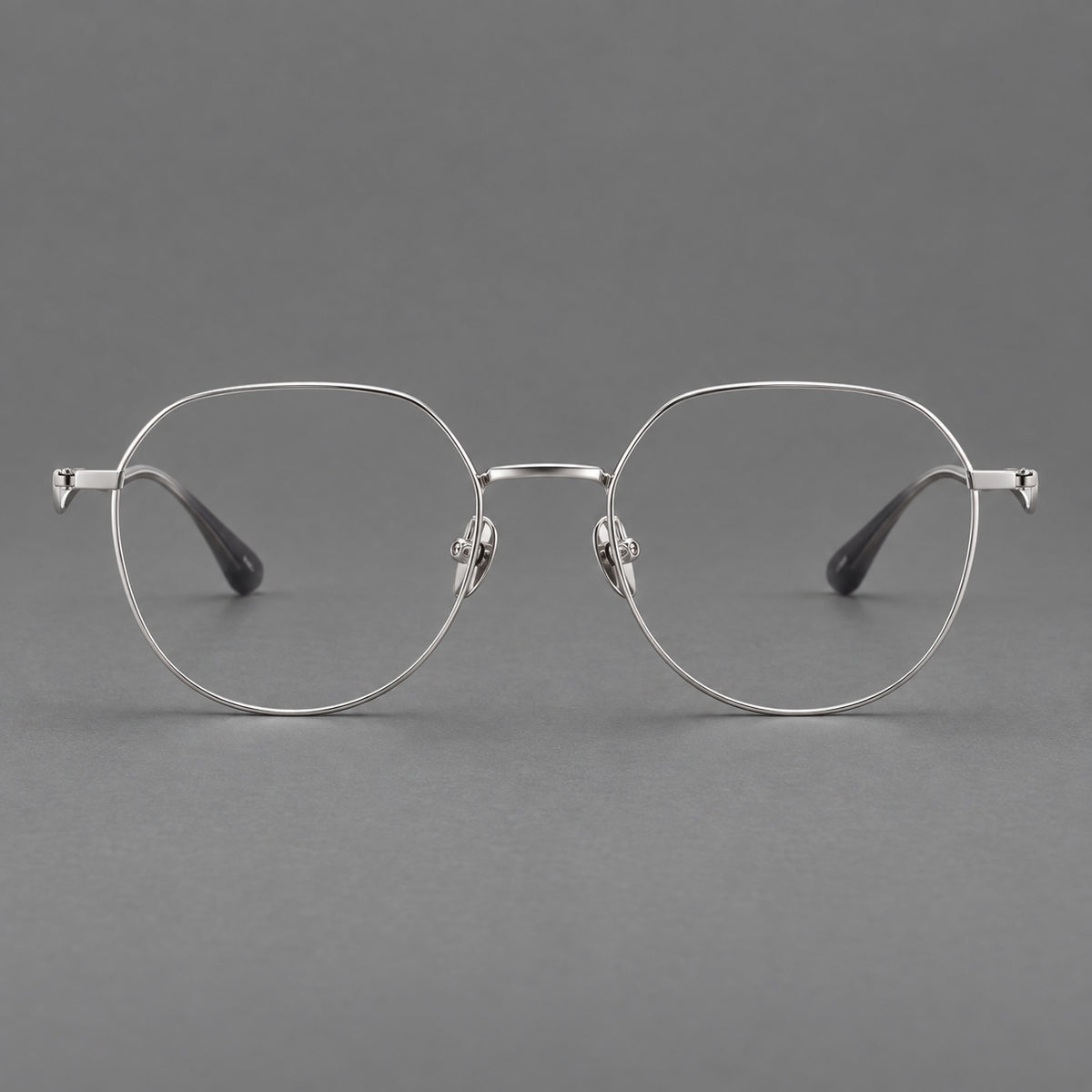 Rounded titanium glasses with a short bridge and distinctive wavy metal temples in Silver, front view
