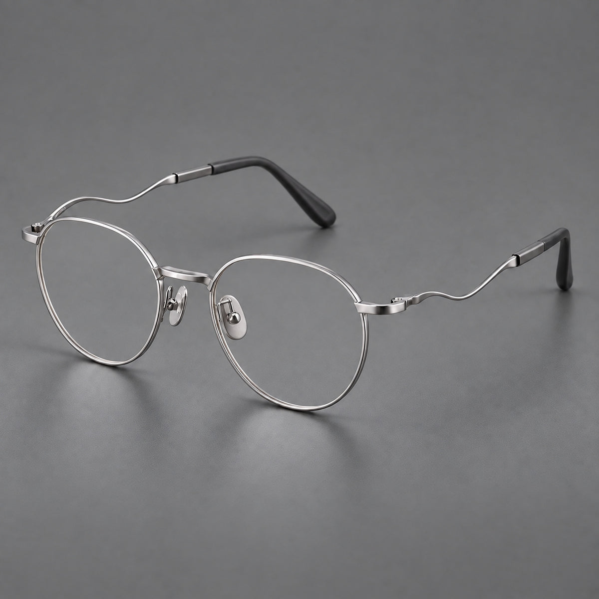 Rounded titanium glasses with a short bridge and distinctive wavy metal temples in Silver, three quarter view