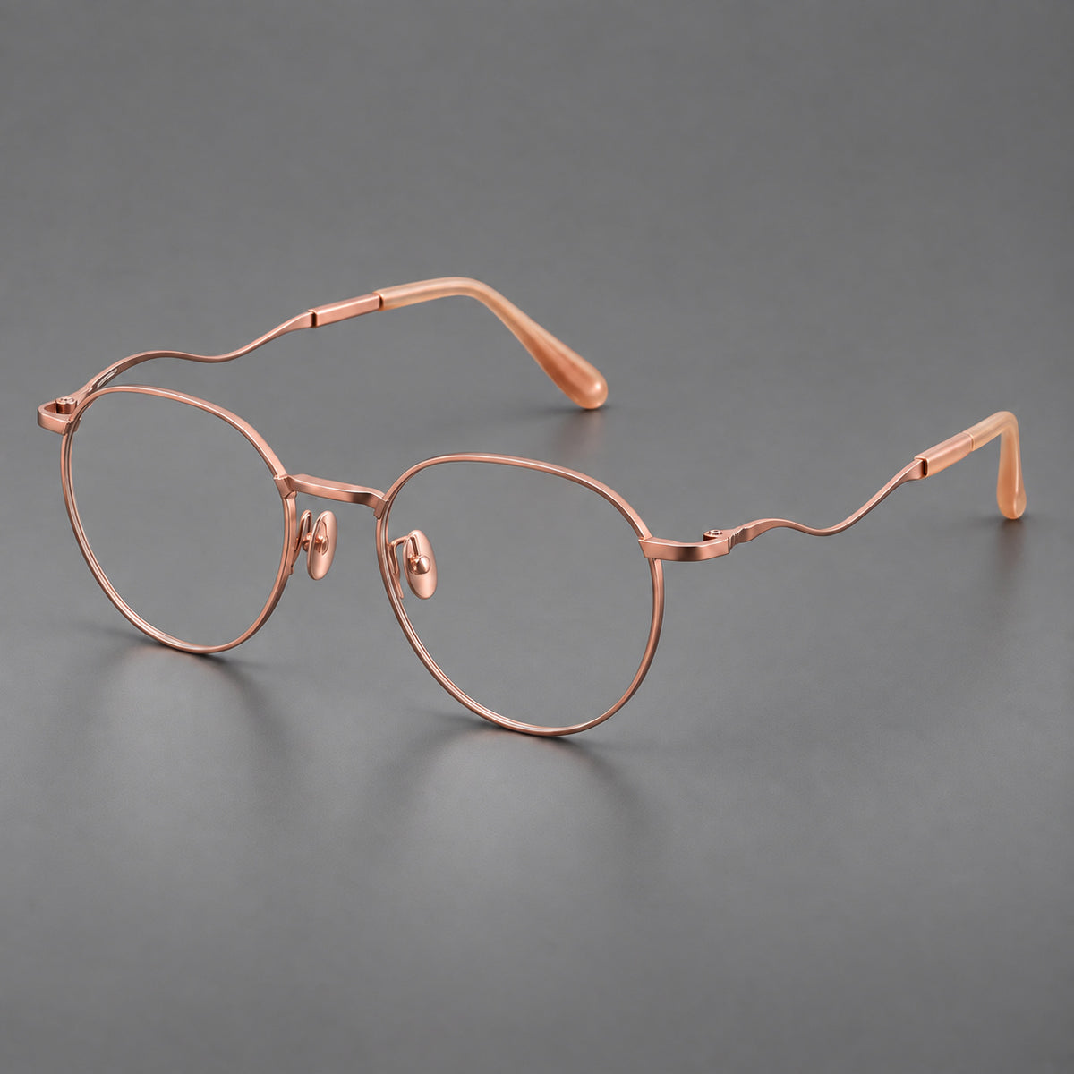 Rounded titanium glasses with a short bridge and distinctive wavy metal temples in Rose Gold, three quarter view