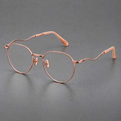 Rounded titanium glasses with a short bridge and distinctive wavy metal temples in Rose Gold, three quarter view additional product view
