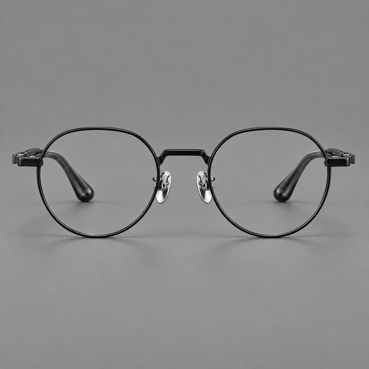 Small panto titanium glasses with an angular bridge and recessed temple details in Black, front view