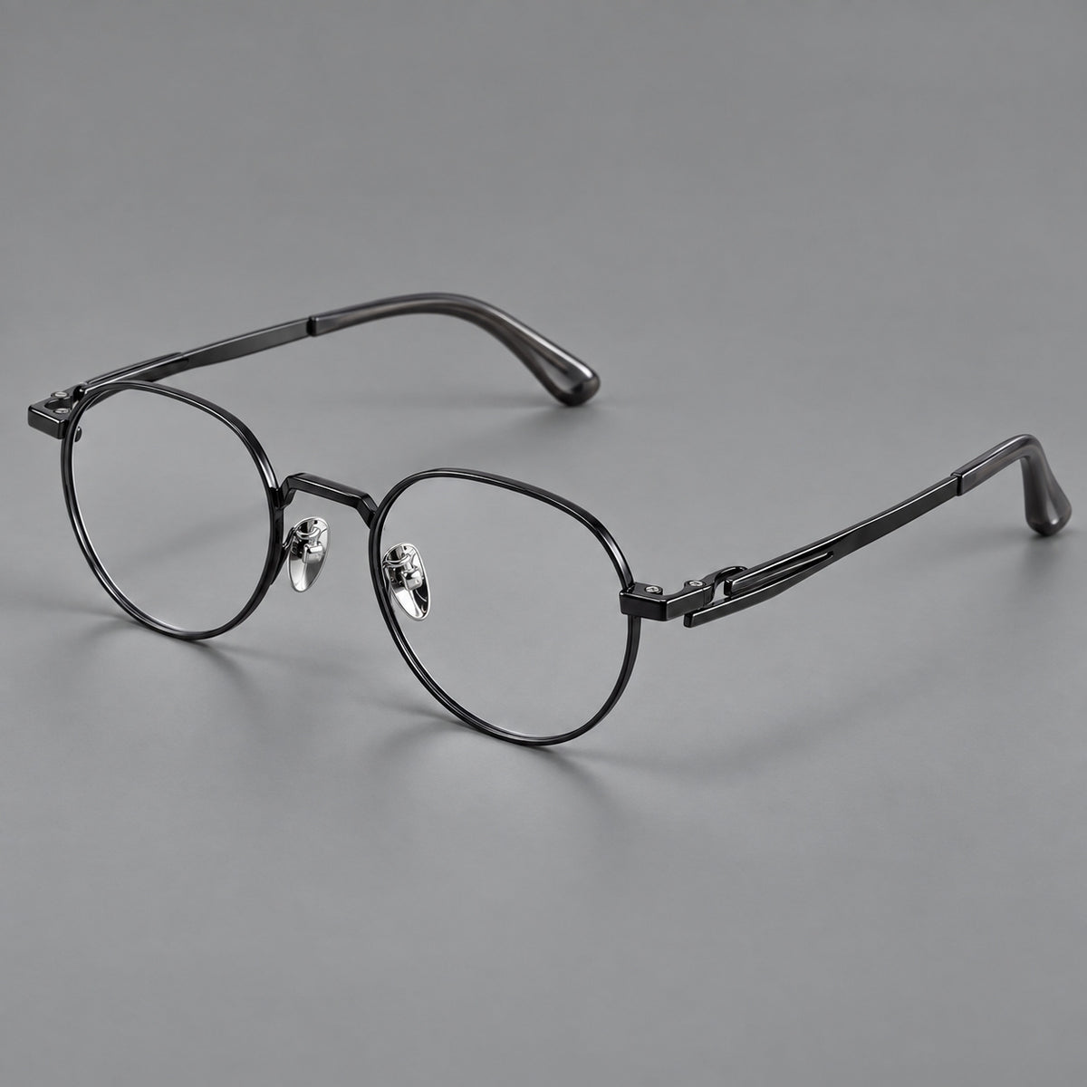 Small panto titanium glasses with an angular bridge and recessed temple details in Black, three quarter view