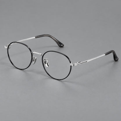 Small panto titanium glasses with an angular bridge and recessed temple details in Black and Silver, three quarter view lens detail