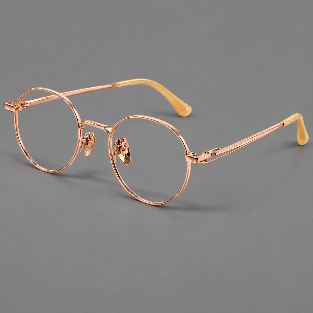 Small panto titanium glasses with an angular bridge and recessed temple details in Rose Gold, three quarter view