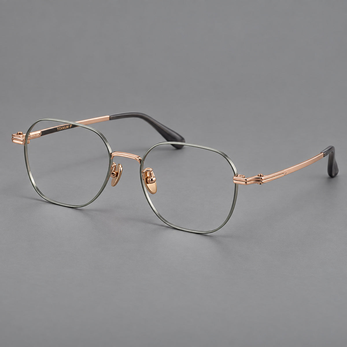 Soft square titanium glasses with an angular bridge and layered corner details in Green and Rose Gold, three quarter view