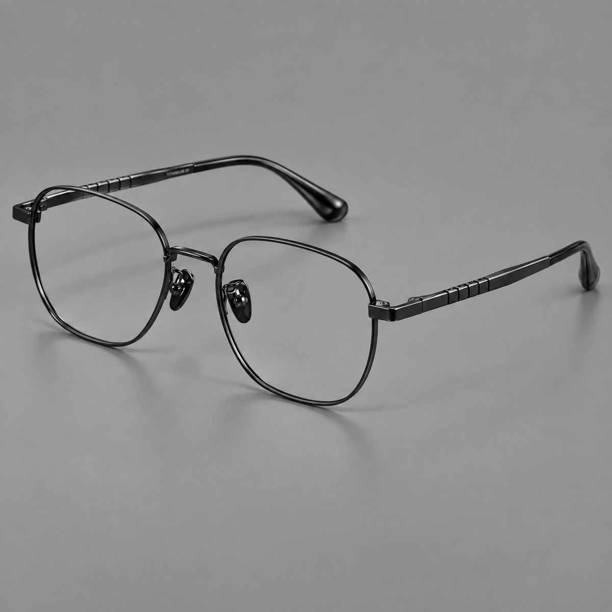Soft square titanium glasses with a raised bridge and engraved temple bands in Black, three quarter view