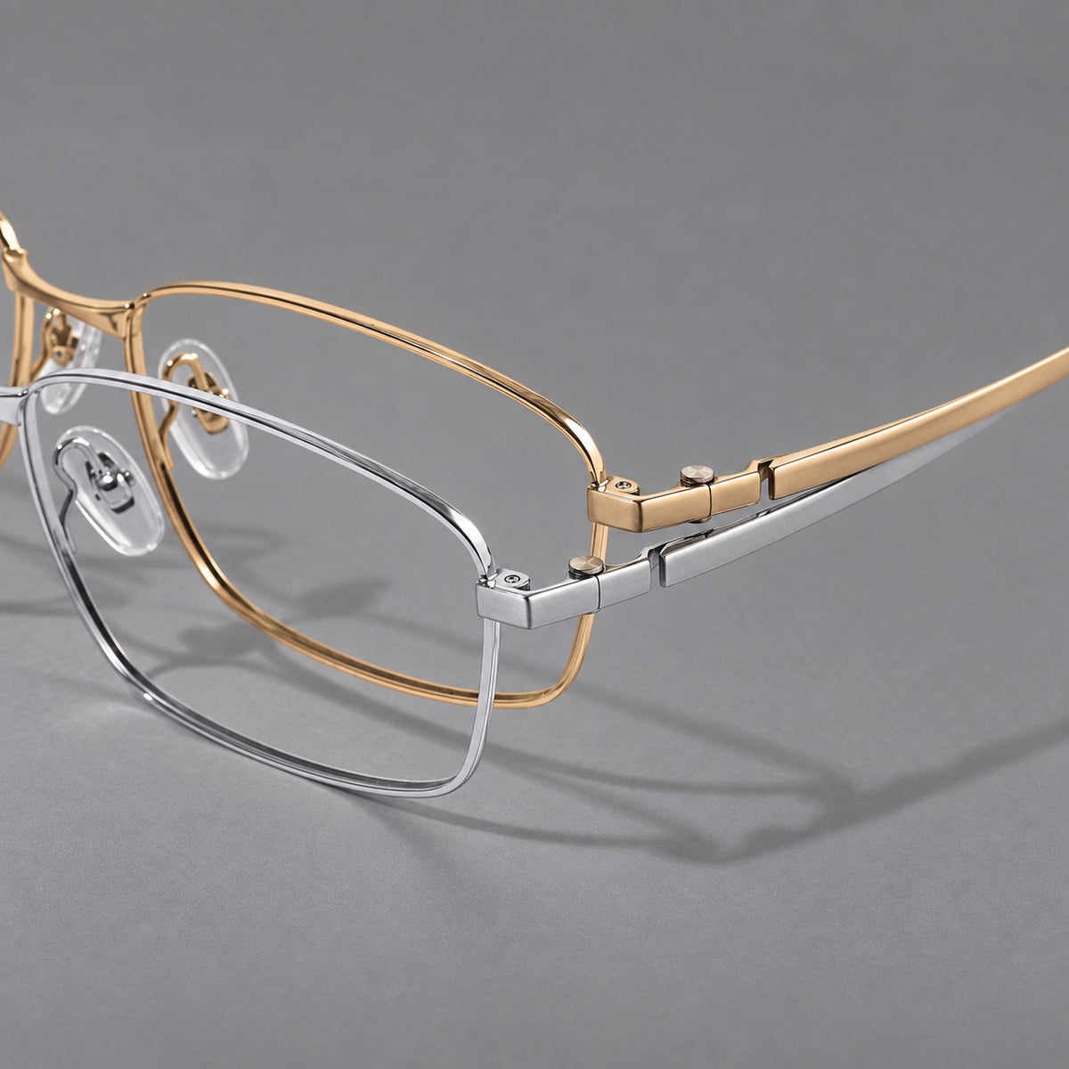 Wide rectangular titanium glasses with a broad bridge and rounded hinge caps, frame details