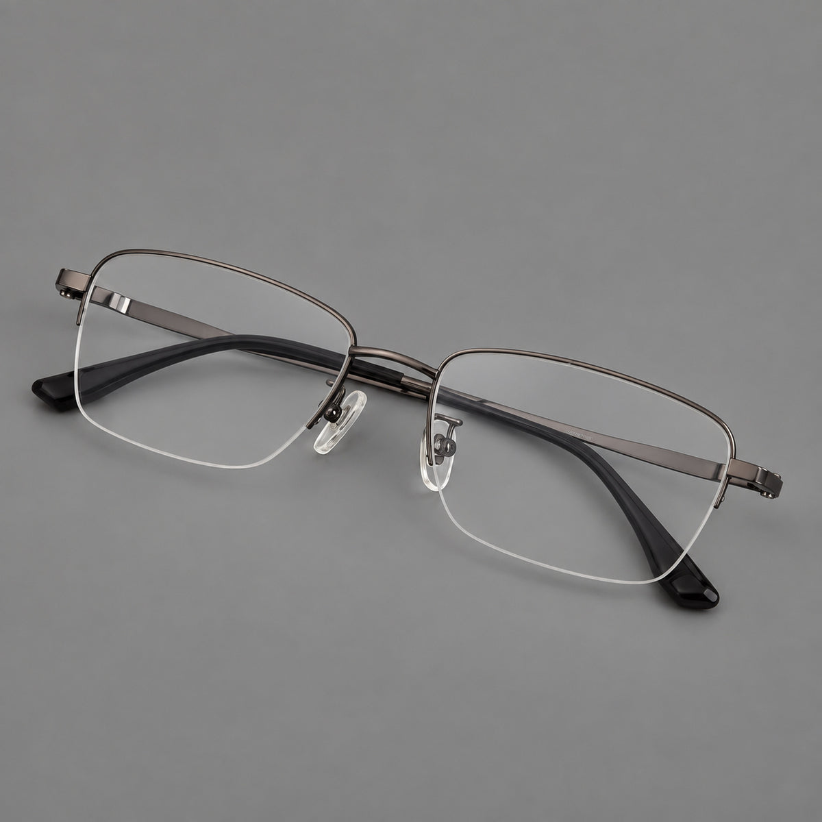Half frame titanium glasses with rectangular lenses and rounded hinge details in Gunmetal, three quarter view