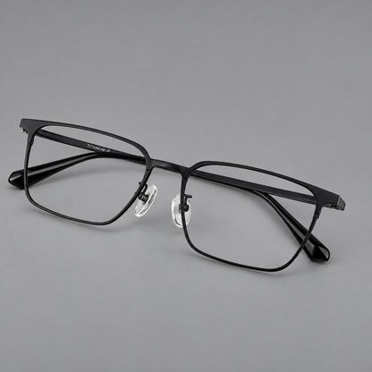 Bold rectangular titanium glasses with strong upper corners and flat metal temples in Black, three quarter view