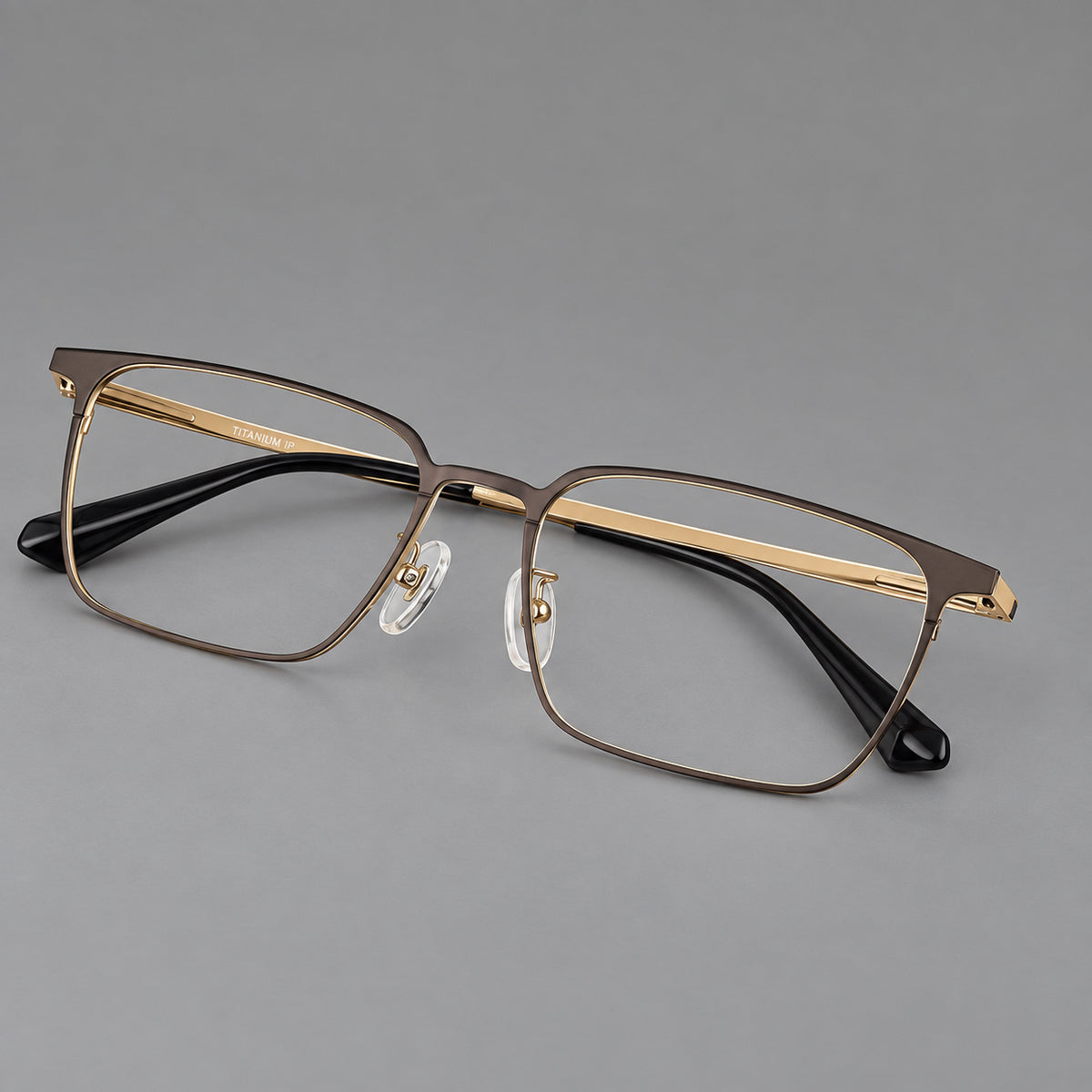 Bold rectangular titanium glasses with strong upper corners and flat metal temples in Gold, three quarter view