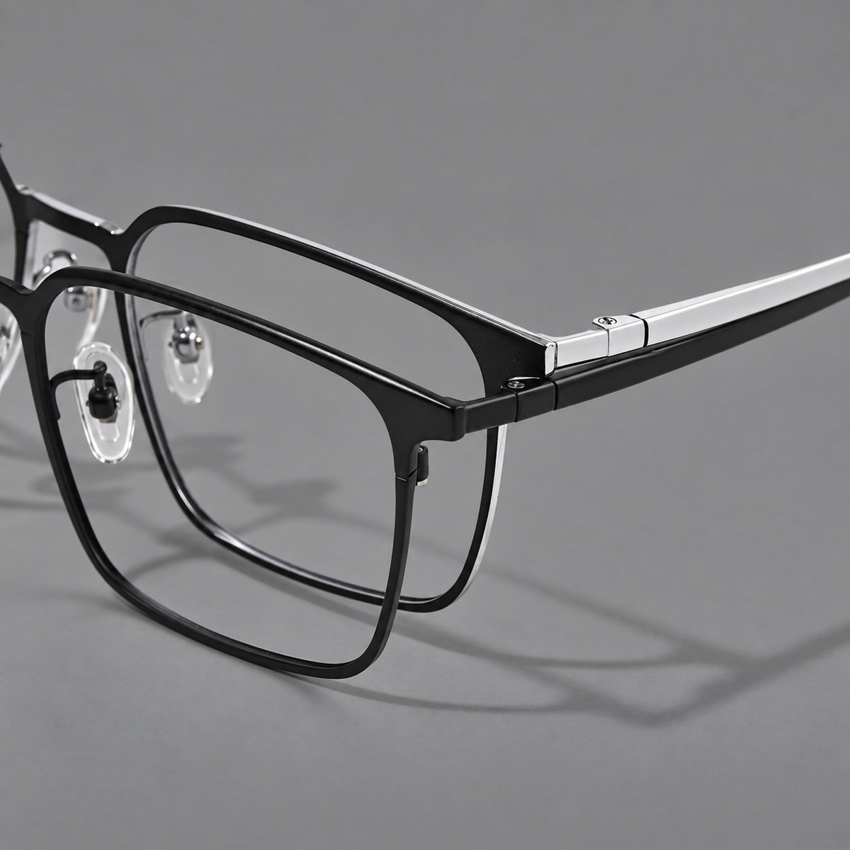 Bold rectangular titanium glasses with strong upper corners and flat metal temples, frame details