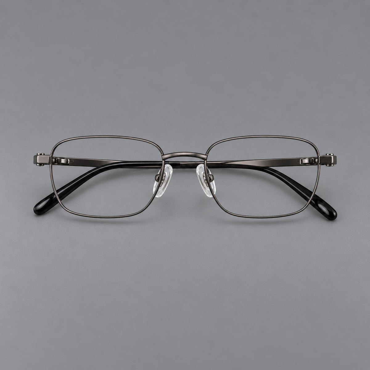 Shallow rectangular titanium glasses with a broad bridge and stepped temple joins in Gunmetal, front view